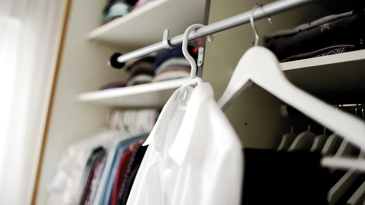 Organized closet with matching white hangers and neatly hung clothes